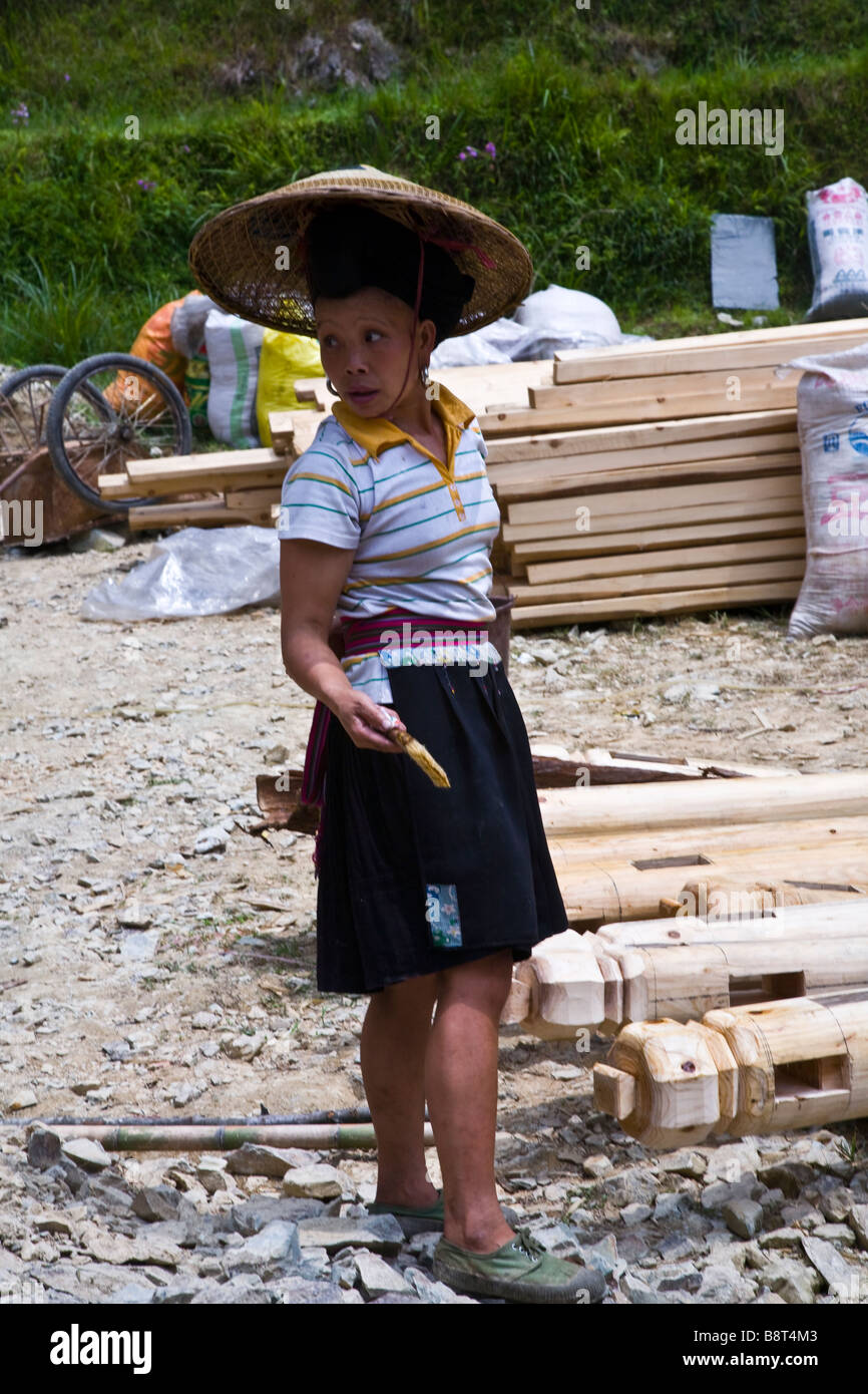 Un Zuhang femme travaillant sur un site de construction en bois traditionnel, Longshen Guanxi Province, China. Banque D'Images