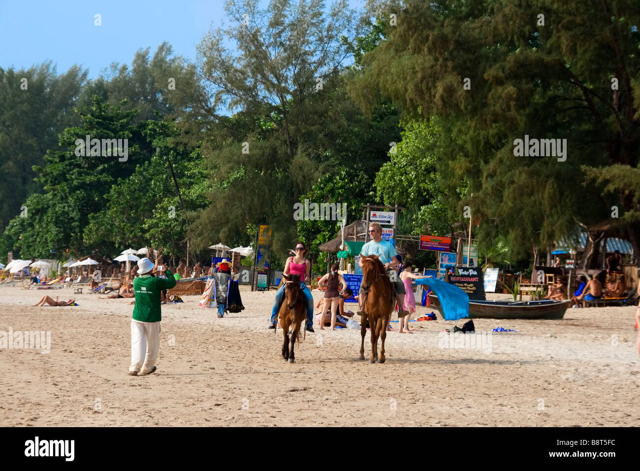 La vie à la plage au restaurant de poissons funky à Long Beach les touristes sur les chevaux Koh Lanta Thaïlande Banque D'Images