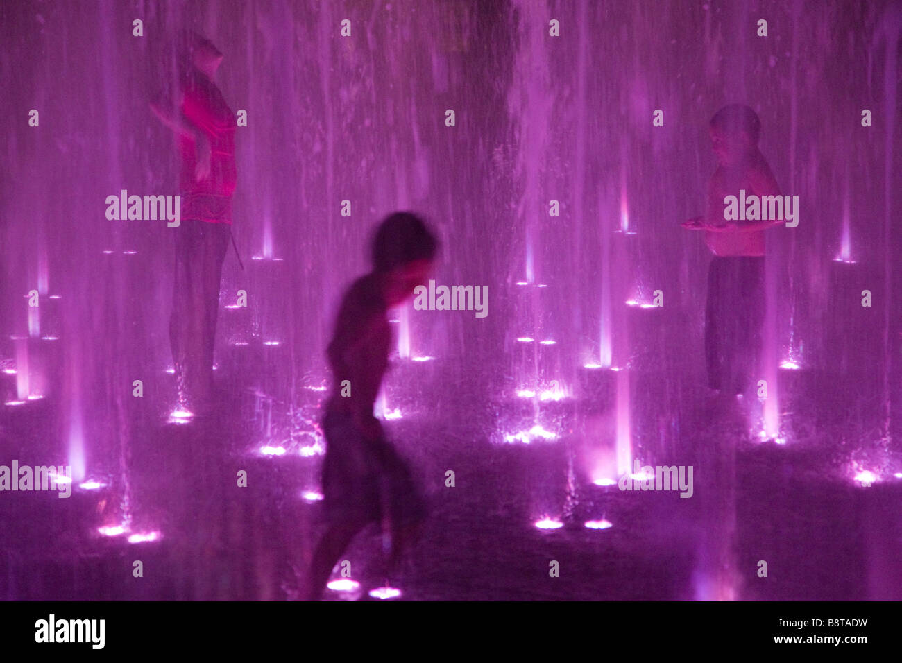 Austin, Texas - Les enfants jouent dans la fontaine lumineuse à Bulter parc de nuit Banque D'Images