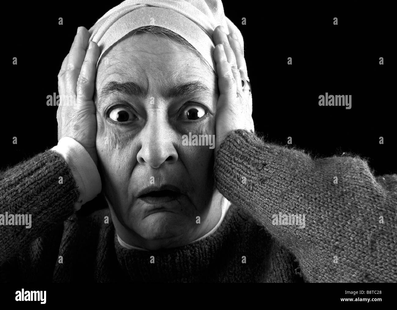Noir et blanc portrait d'une femme mature à la peur, peur, avec la tête dans ses mains Banque D'Images