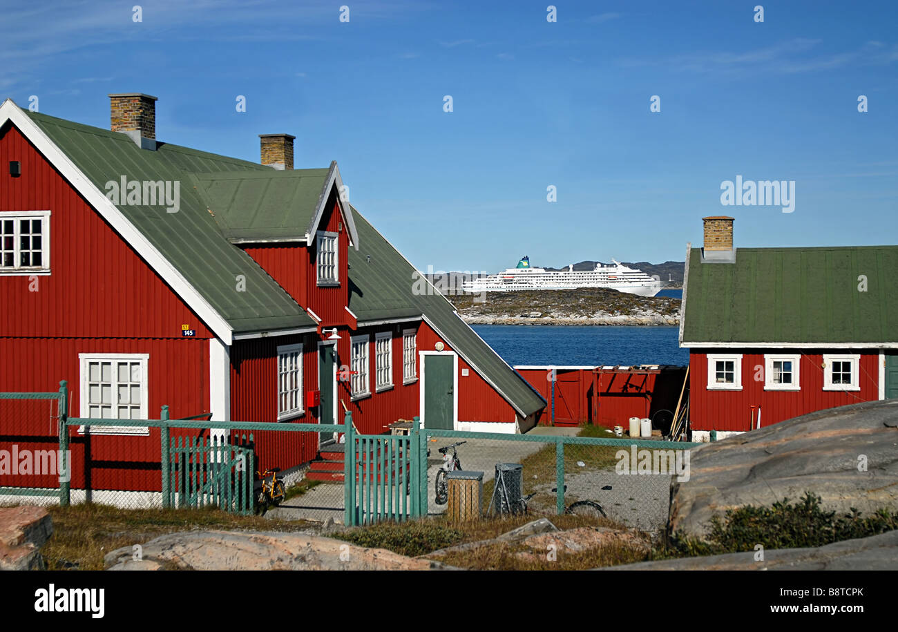 Maison traditionnelle dans un village de pêcheurs du Groenland avec un bateau en arrière-plan, Groenland Banque D'Images