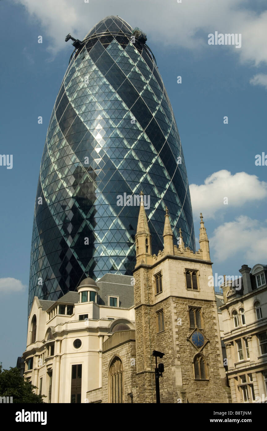 Le Gherkin building avec une vieille église au premier plan Banque D'Images