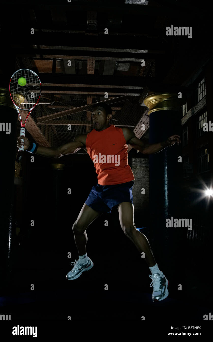Joueur de tennis, homme jouant au tennis, le temps est limité, le temps est précieux et va jouer n'importe où après le travail, forehand smash, battant. Banque D'Images