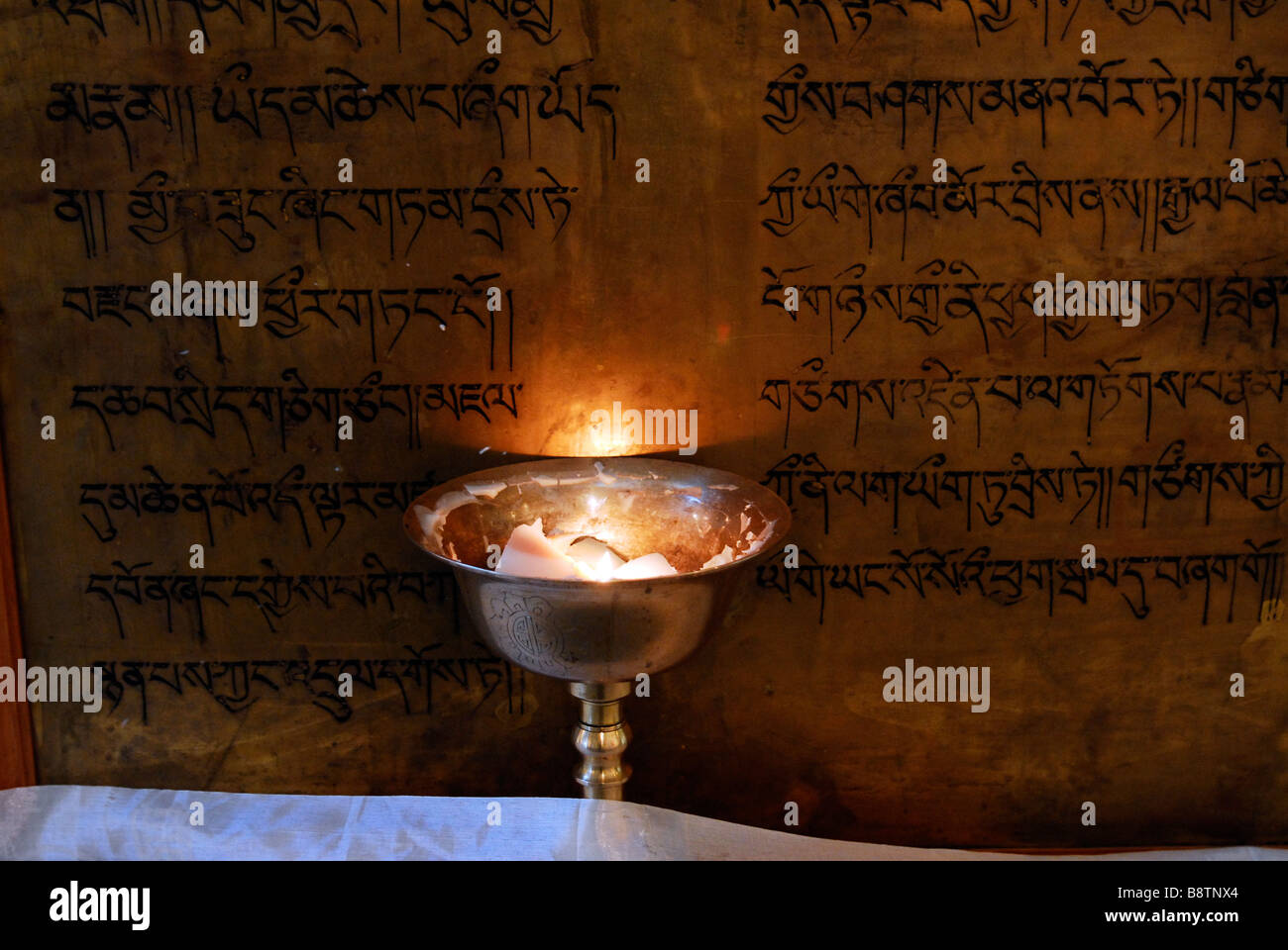 Écritures tibétain éclairé par une lampe à beurre. McLeod Ganj, Himachal Pradesh, Inde Banque D'Images