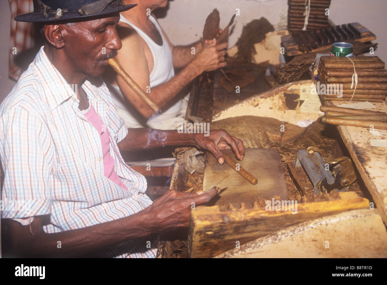 Homme cubain noir faisant rouler à la main les cigares de la Havane dans une petite usine À Cuba Banque D'Images