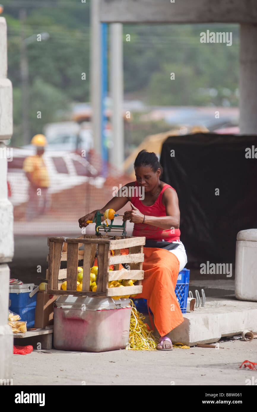 Peler les oranges, femme de vendre aux feux de circulation. La ville de Panama, République de Panama, Amérique Centrale Banque D'Images