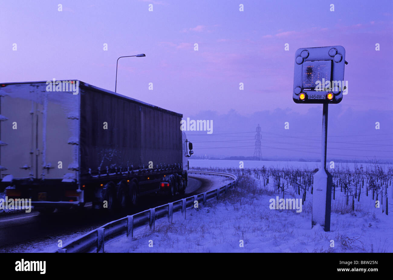 Panneau d'avertissement de passage de camion d'une réduction de la limite de vitesse sur autoroute en raison de la neige de l'hiver près de Leeds Yorkshire UK Banque D'Images