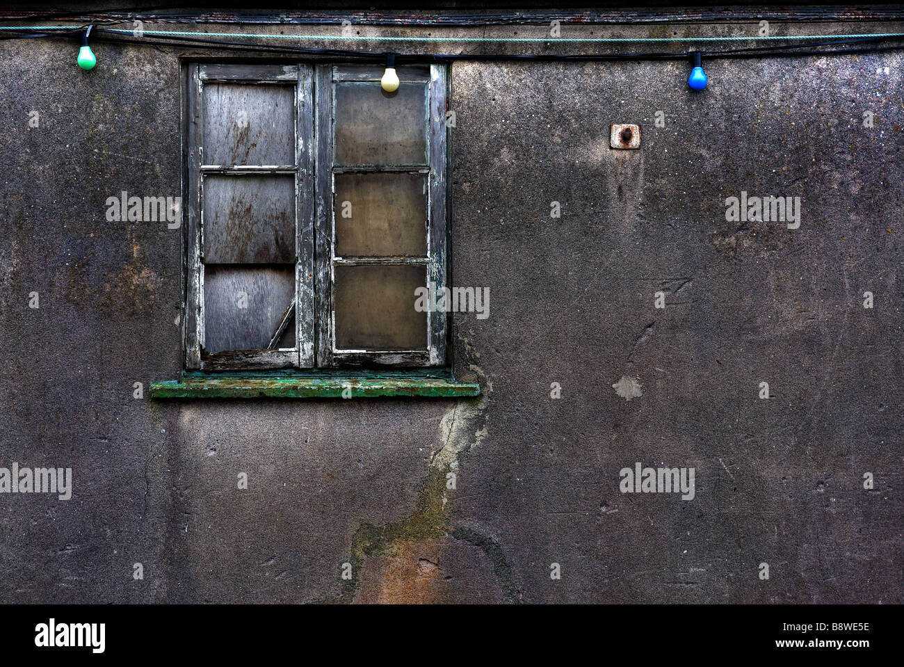 Une fenêtre délabrée dans un mur de béton. Banque D'Images