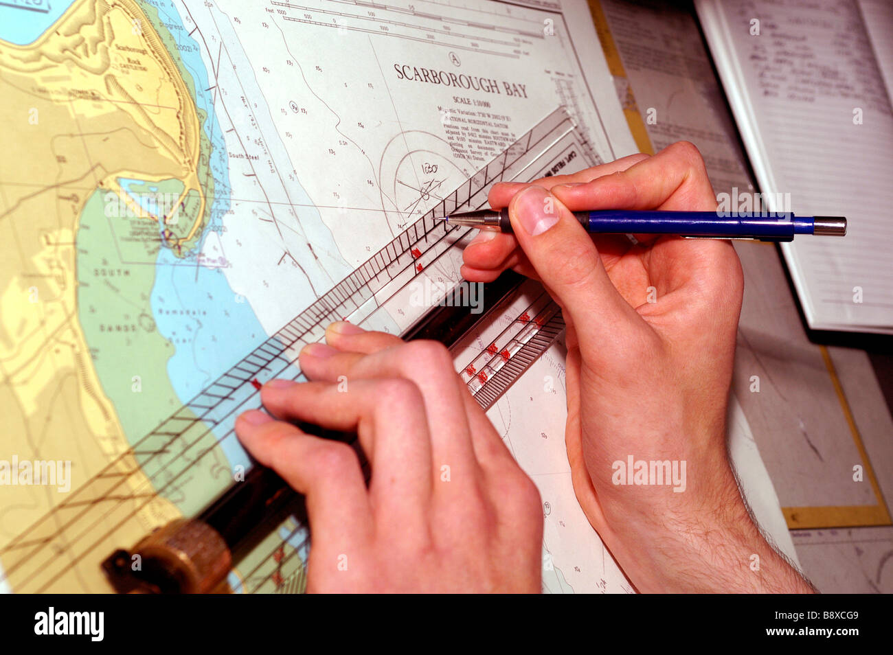 Un officier de la Royal Fleet Auxiliary trace la position du navire sur une carte marine sur le pont de la Wave Ruler Banque D'Images