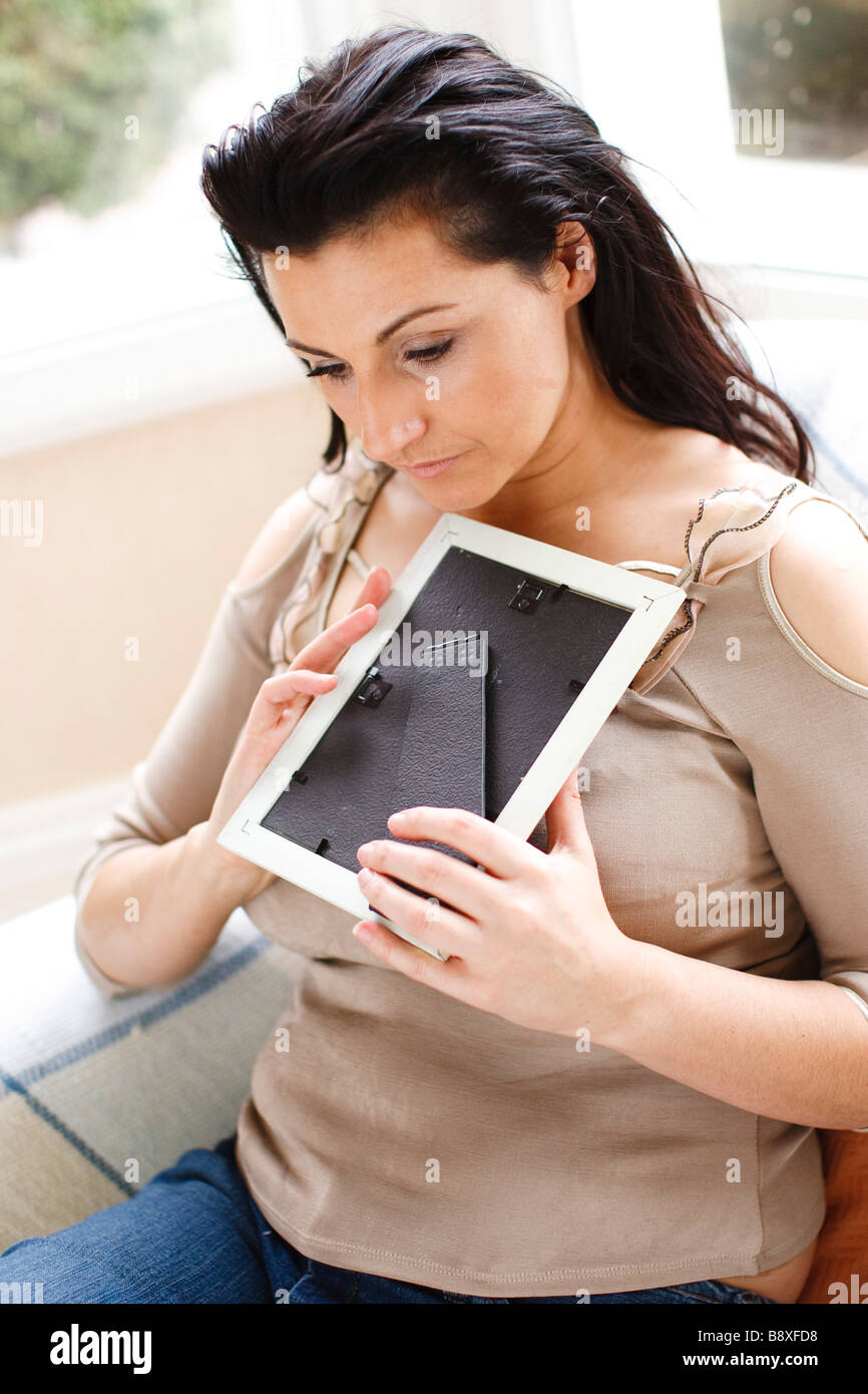 Woman holding photo frame Banque D'Images