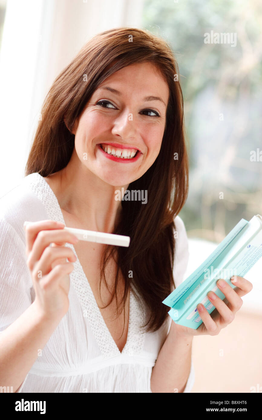 Femme heureuse avec les résultats de test de grossesse Banque D'Images