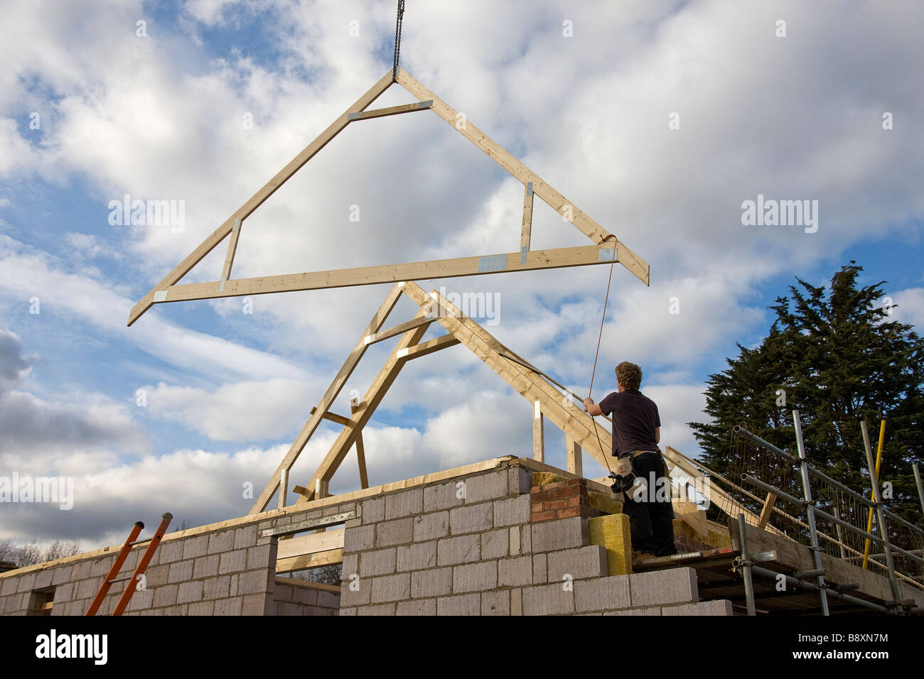 Charpente de toiture Bois Grenier d'être abaissé en position sur le toit de la nouvelle maison. Banque D'Images