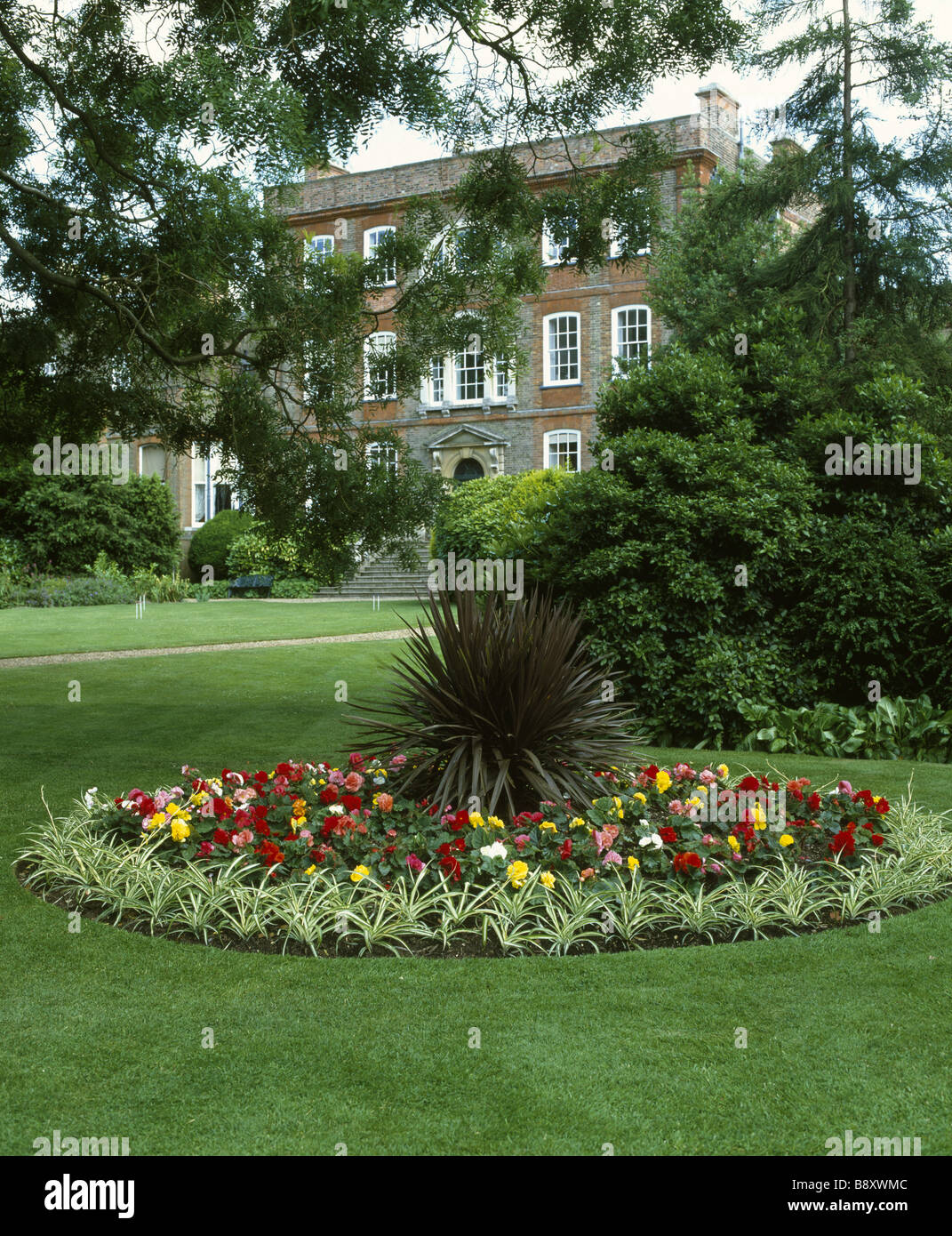 Une île plantée de lit en typique style Victorien avec des bégonias sur la pelouse à l'Palm Peckover House Banque D'Images