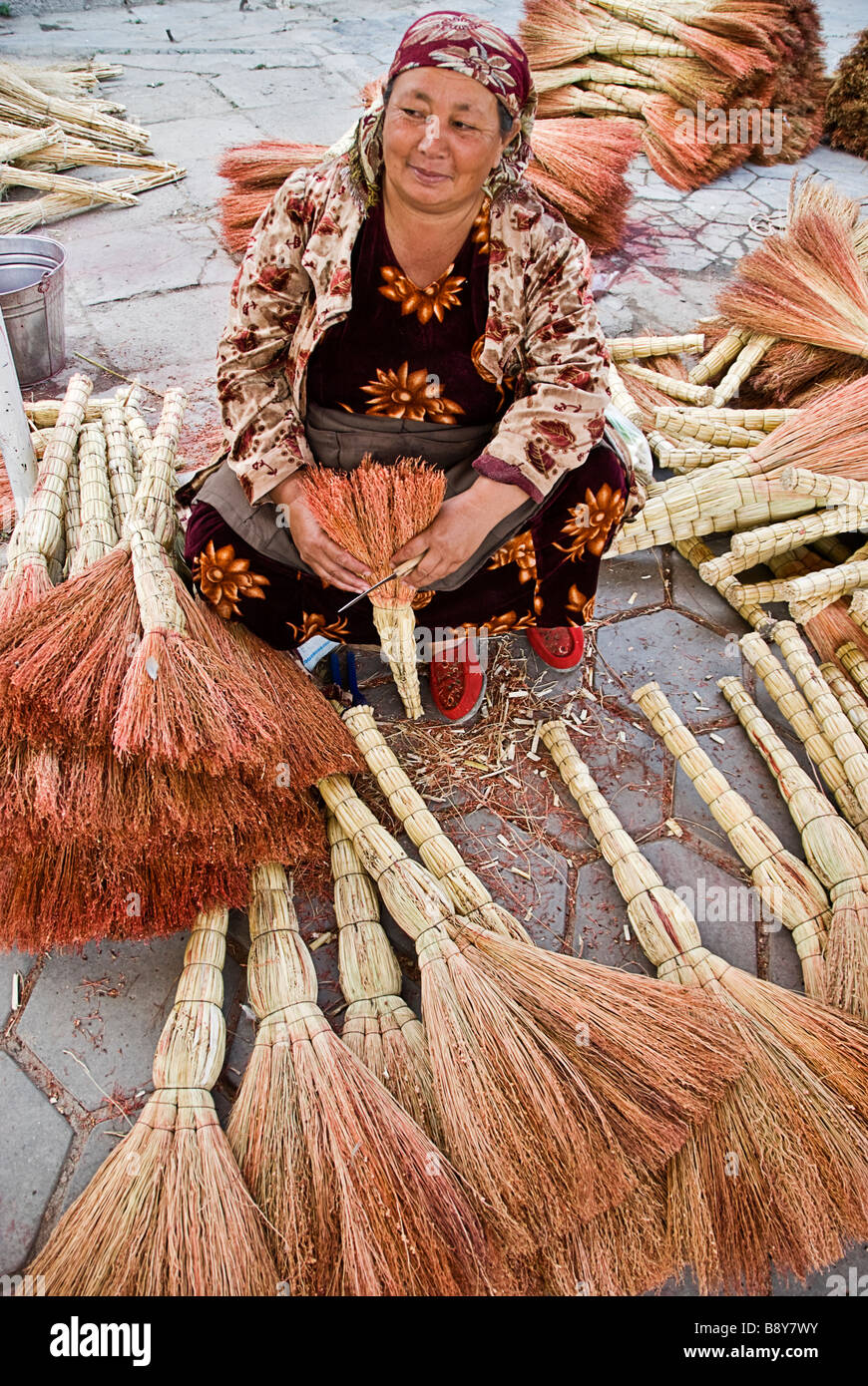 Femme vendant des pinceaux dans un marché de rue, Samarcand, Ouzbékistan Banque D'Images