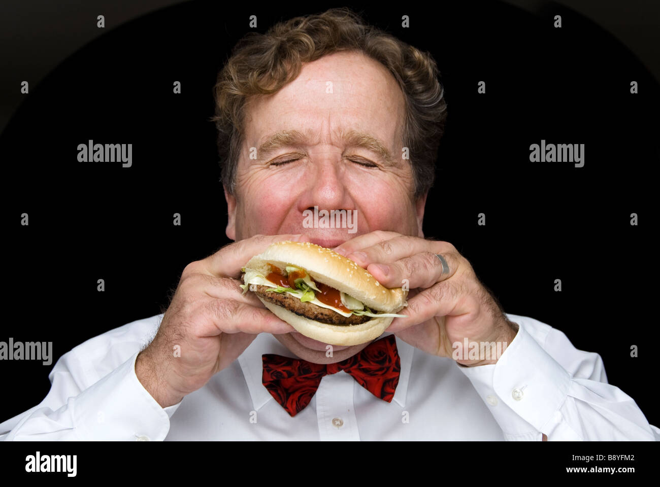 L'homme de manger un hamburger Banque D'Images