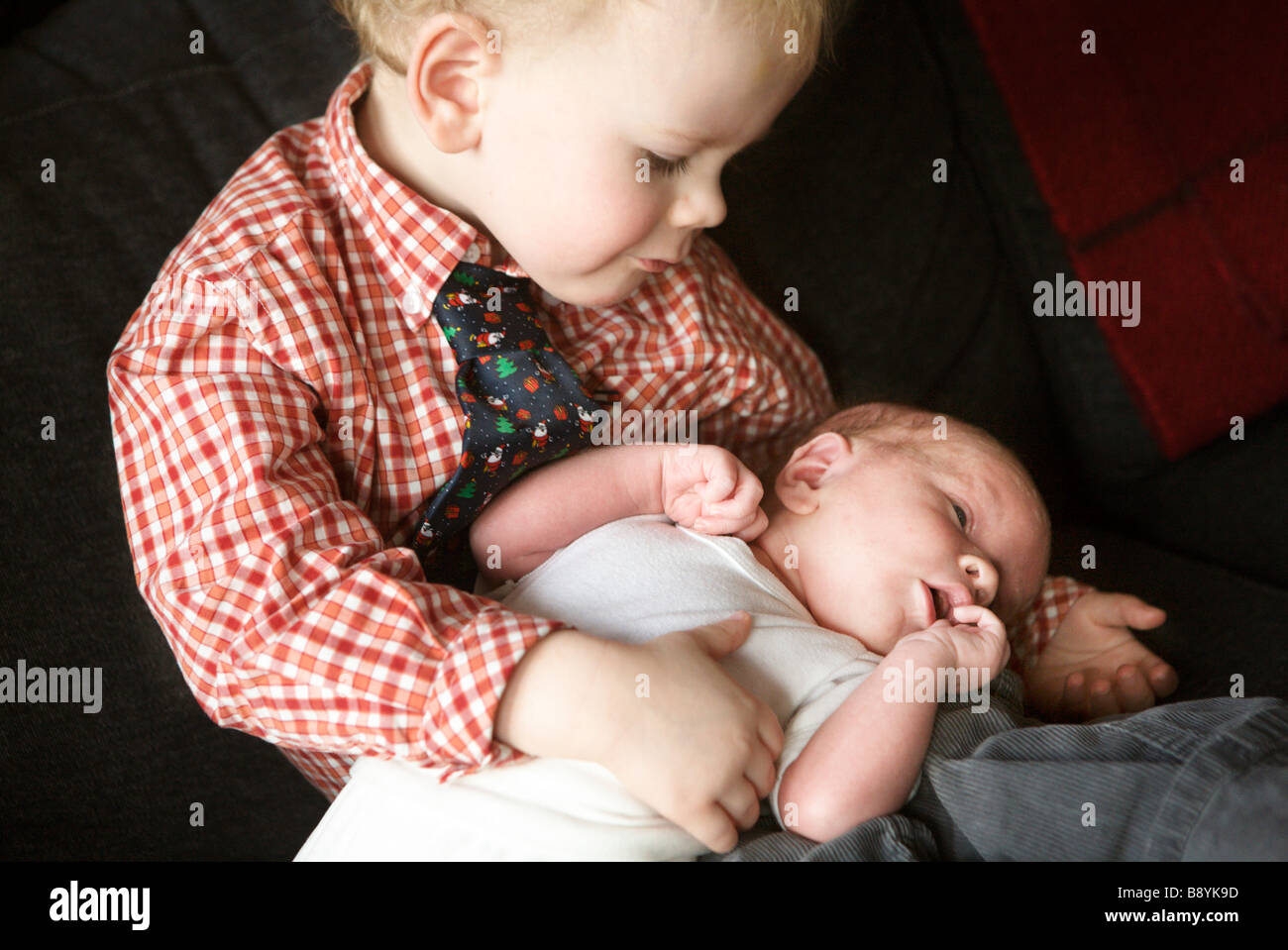 Un petit garçon tenant un bébé. Banque D'Images