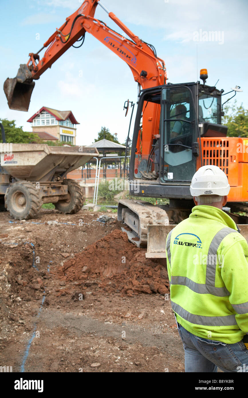 Jcb le déchargement d'un camion à benne à terre en Angleterre, Royaume-Uni. Banque D'Images