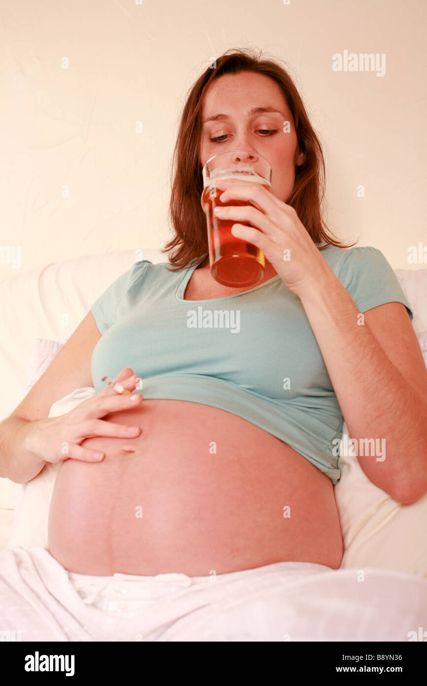 Femme enceinte de boire pinte de bière en verre d'alcool et plus de  cigarettes Fumer nuit à foetus baby smiling mauvais régime health Photo  Stock - Alamy