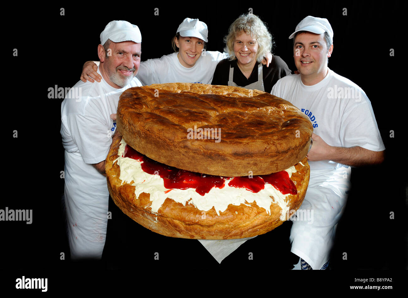 Les boulangers Nick Amy et Mary Lovering et collègues baker Simon Clarke avec leur plus grand monde géant cuit scone à Torrington, UK Banque D'Images