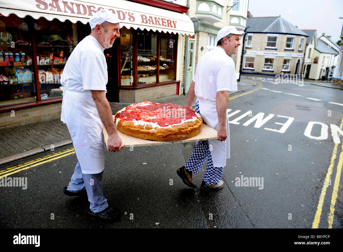 Les boulangers Nick Lovering et Simon Clarke portent leur plus gros géant scone cuit dans la boulangerie Sandfords à Torrington, Devon UK Banque D'Images