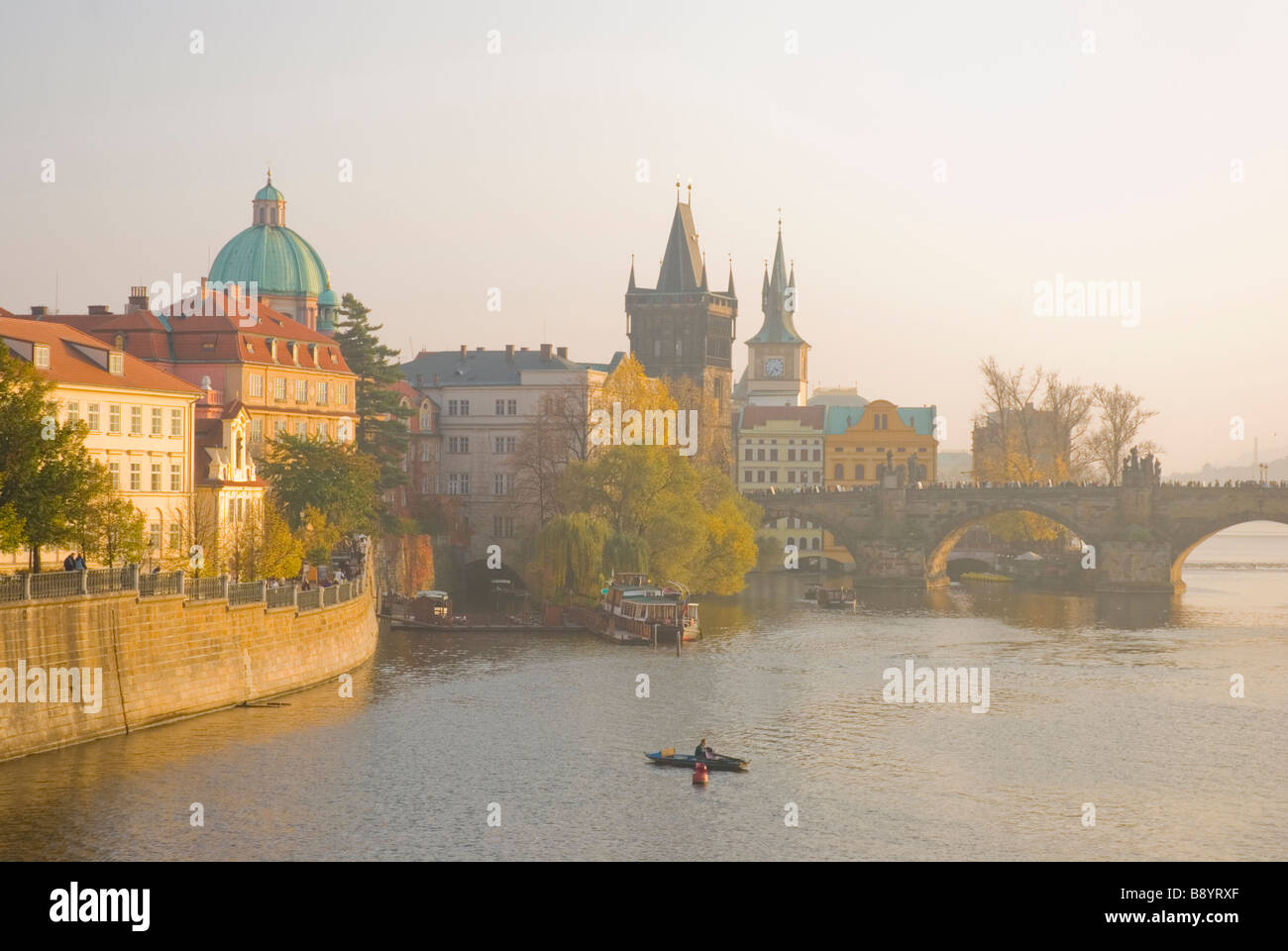 Rivière Vltava pêcheur et le pont Karluv Most Charled au coucher du soleil, dans le centre de Prague République Tchèque Europe Banque D'Images