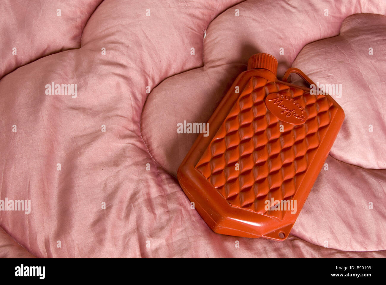 Une petite bouteille d'eau chaude sur un édredon rose dans le dortoir des enfants à la workhouse, Southwell, Nottinghamshire Banque D'Images