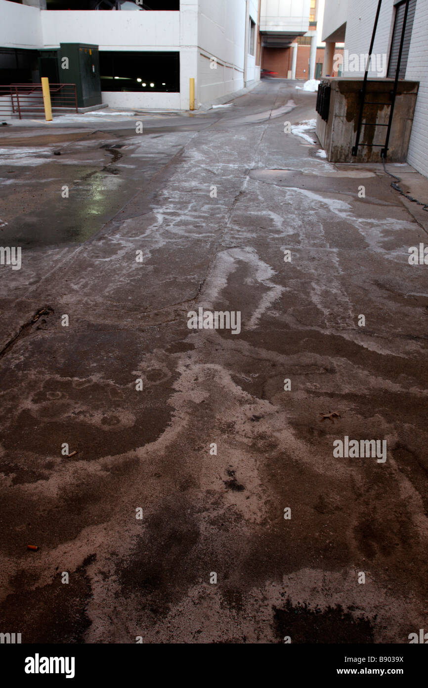 Les résidus de sel et de glace sur la chaussée en alley Banque D'Images