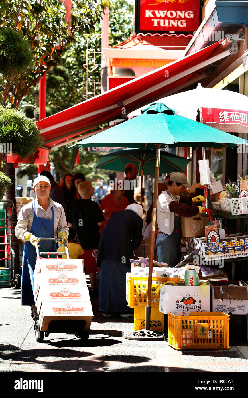 Les travailleurs chinois et les clients à faire leurs achats à l'extérieur sur la rue-de-Fisgard dans le quartier chinois de Victoria en Colombie-Britannique, Canada. Banque D'Images