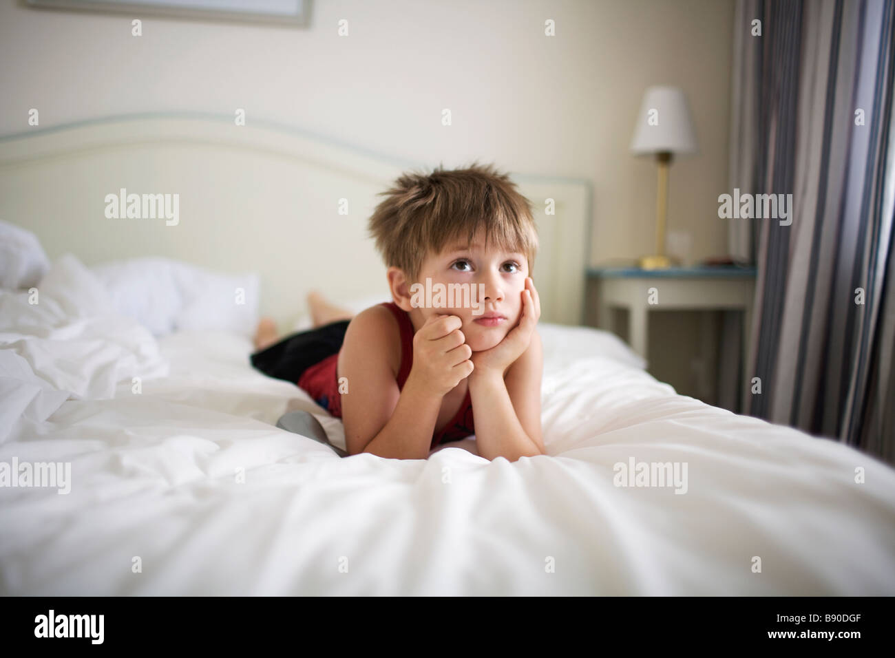 Un garçon couché dans un lit de la Suède. Banque D'Images