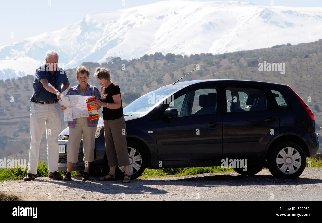 Les touristes avec leur voiture de location à la carte à avec un fond de montagne enneigées dans le sud de l'Espagne Sierra Tejeda Banque D'Images