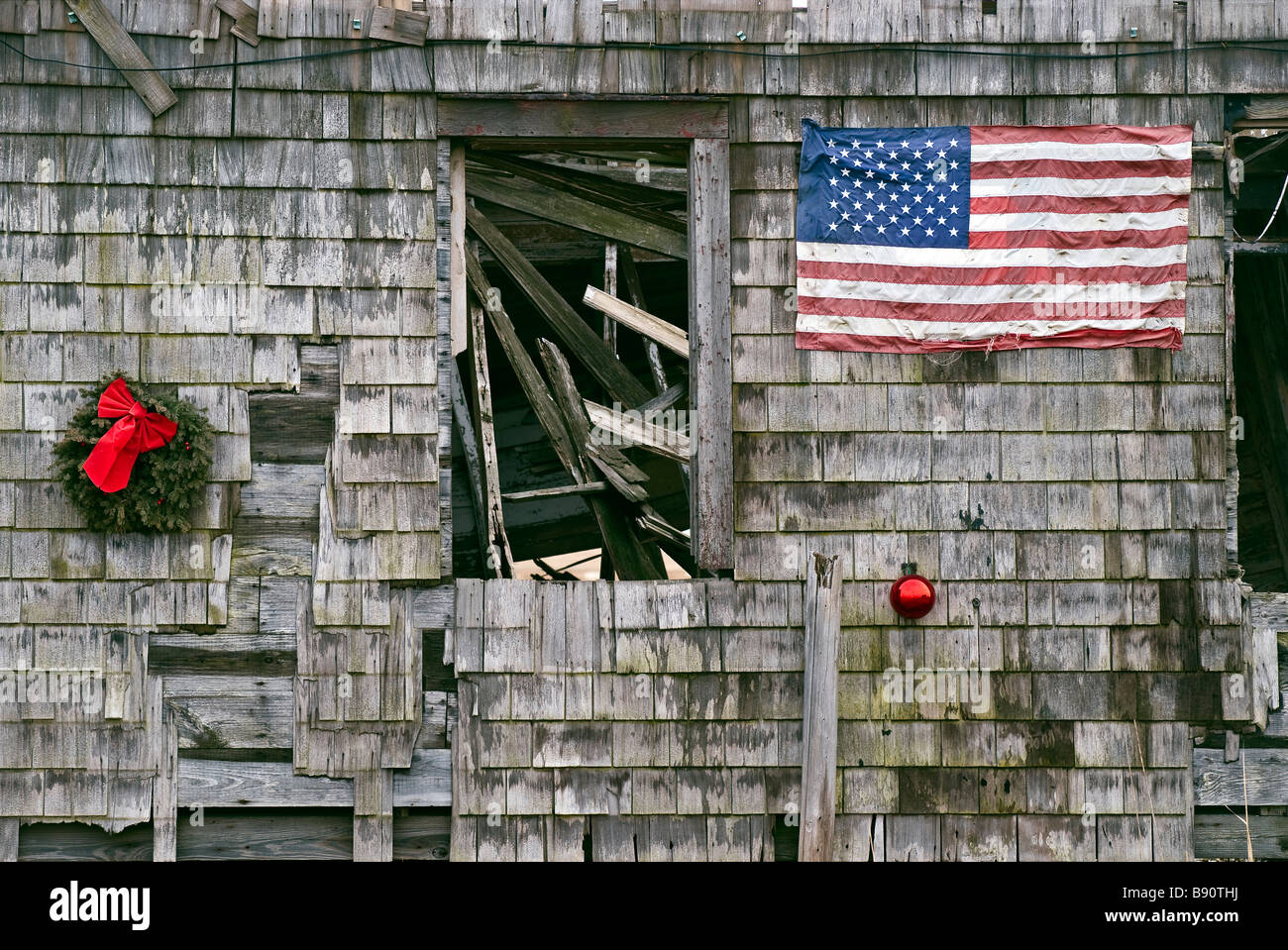 Ornement de Noël et de drapeau américain sur le côté d'une maison abandonnée Banque D'Images