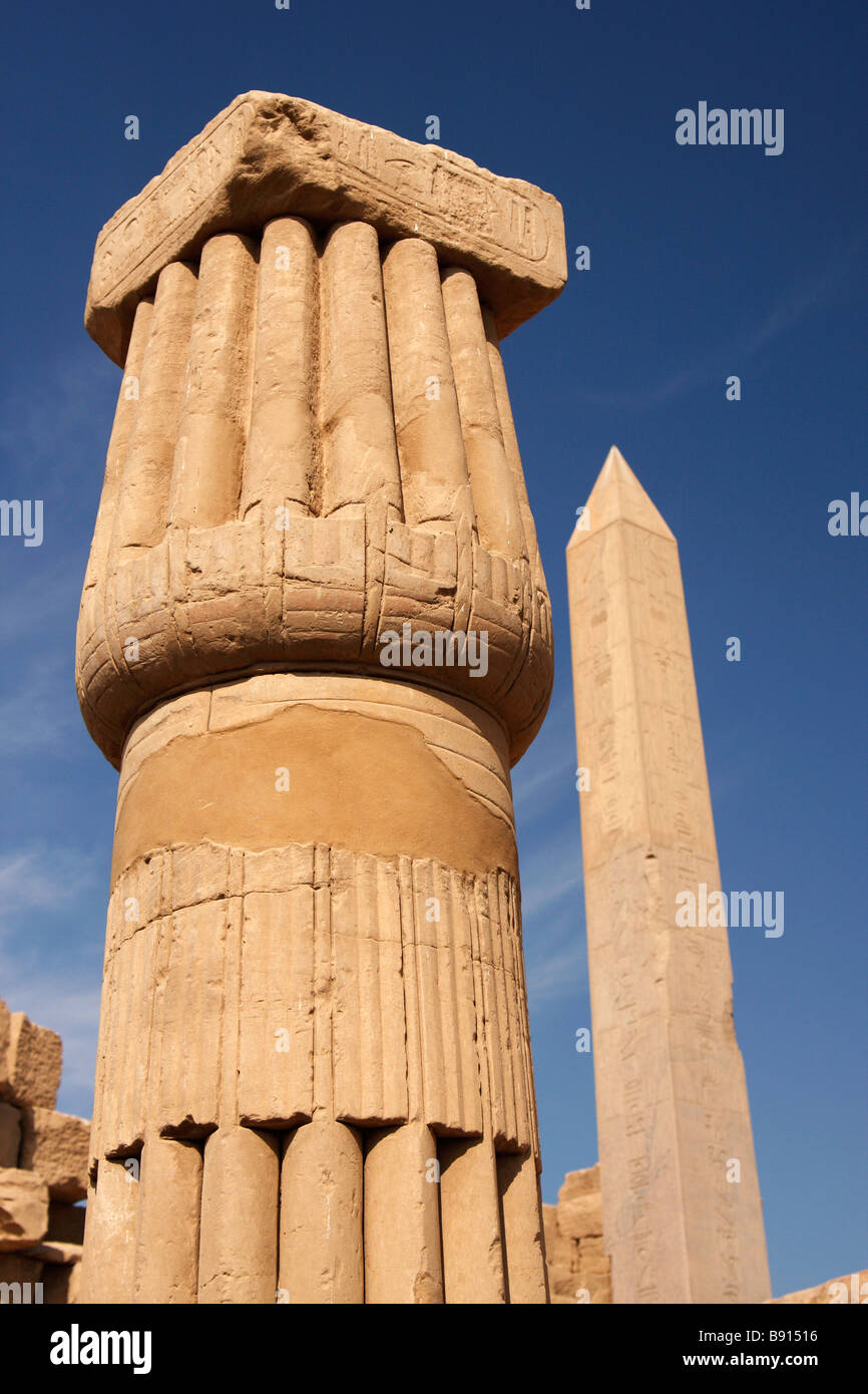 Close up detail de pierre sculptée colonne papyrus avec obélisque de la reine Hatshepsout en arrière-plan, Temple de Karnak, Louxor, Egypte Banque D'Images