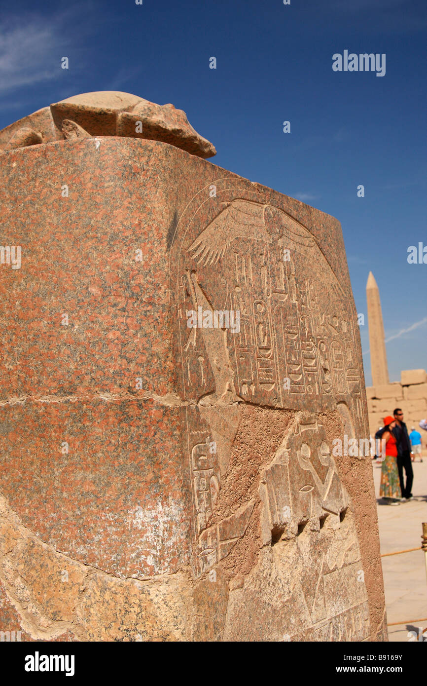 Scarabée sacré statue en pierre sculpté avec socle et les hiéroglyphes, l'obélisque derrière, Temple de Karnak, Louxor, Egypte Banque D'Images