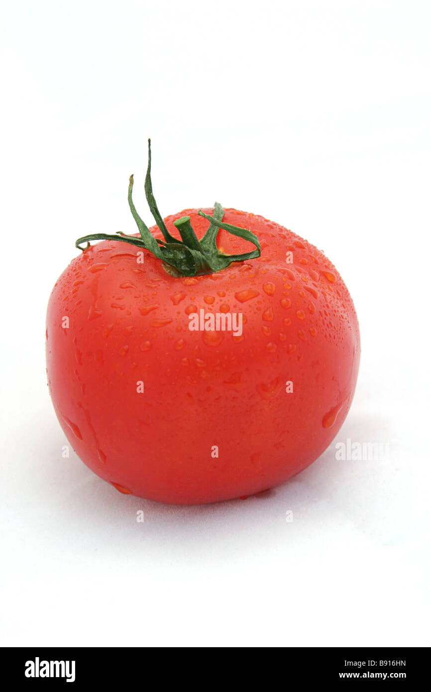 Une tomate rouge juteuse sur un fond blanc orientation verticale Banque D'Images