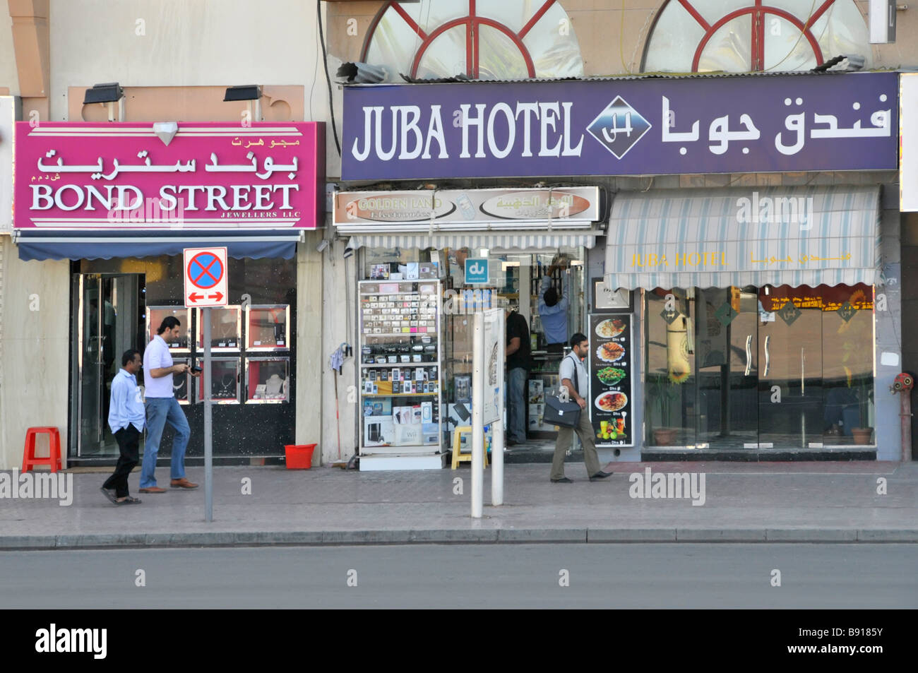 Scène de rue pavée dans la rue Al Khor à Dubaï avec Panneau avant du magasin de bijoux de Bond Street et Juba Bâtiment de l'hôtel Émirats arabes Unis Banque D'Images