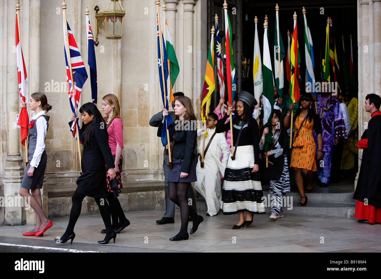 Les jeunes gens portant les drapeaux de la Communauté s'écarter de l'abbaye de Westminster à Londres après la célébration de la Journée du Commonwealth Ser Banque D'Images