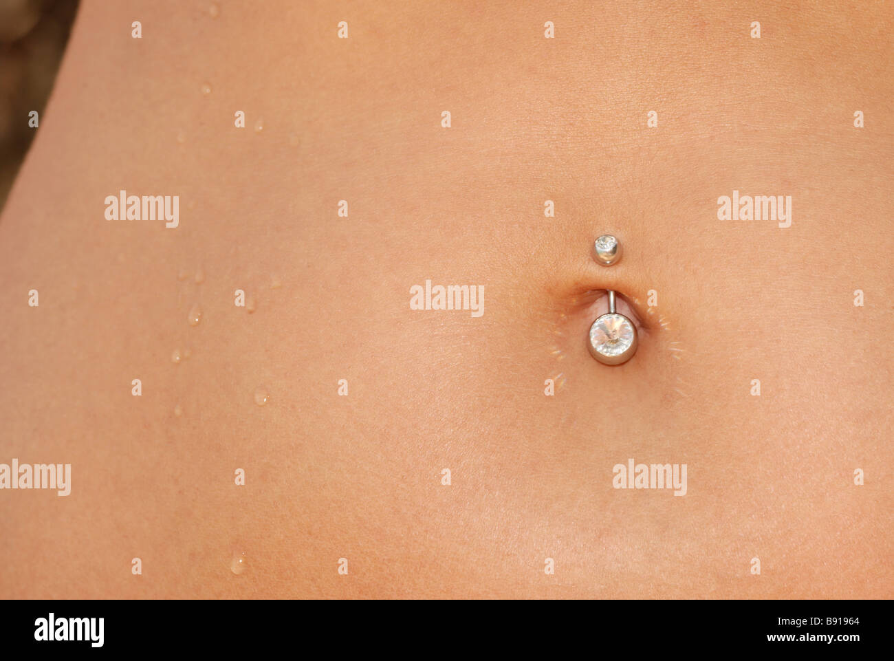 Dans un piercing nombril un corps de femme avec un piercing bijoux Banque D'Images