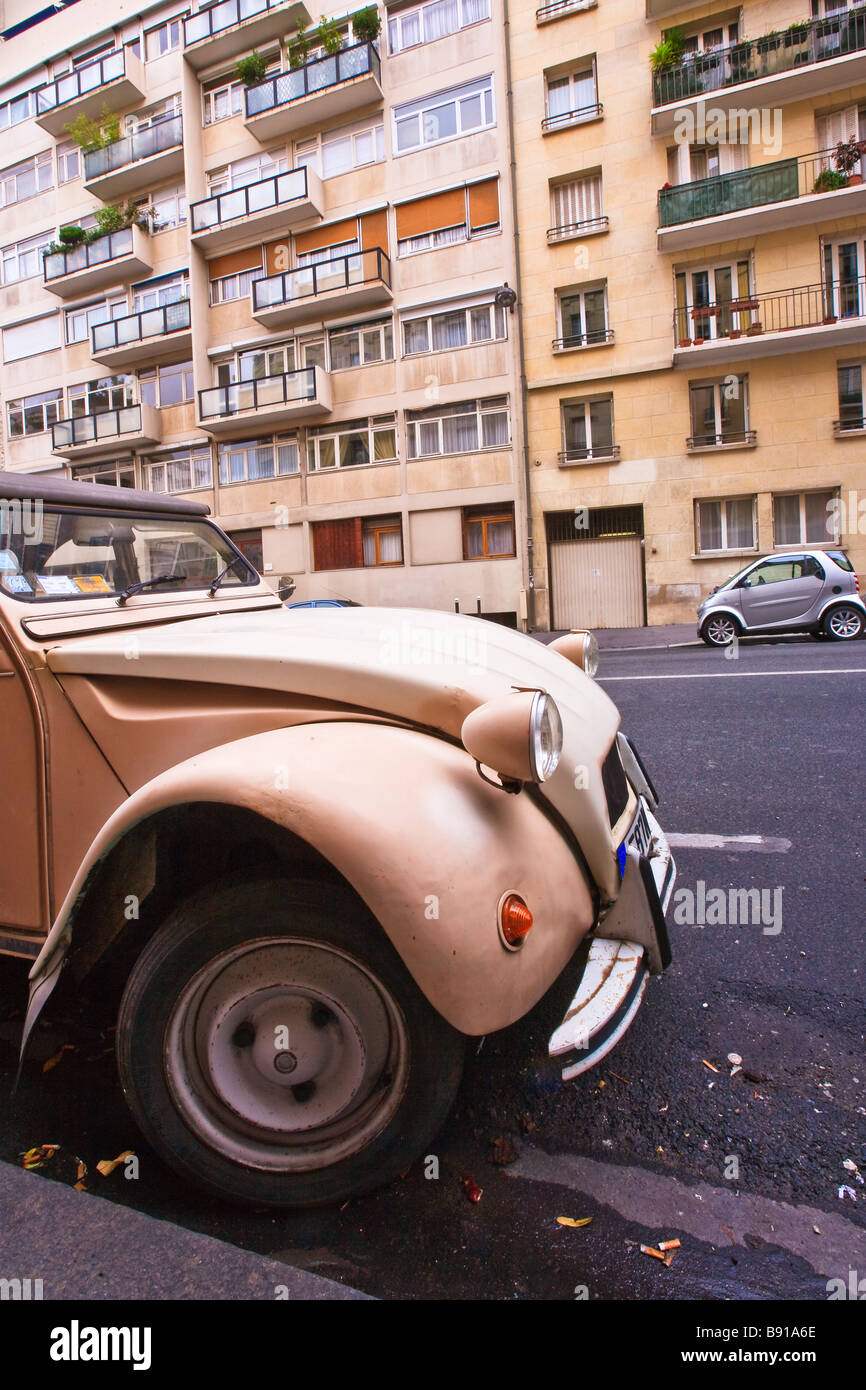 Vieille 2 cv Citroën stationné dans la région de Paris, France. Sur le côté opposé de la route est en stationnement smart. Banque D'Images