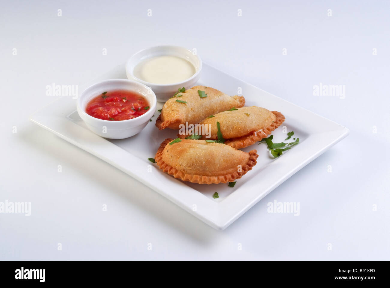 Latin traditionnel de style américain de pâtisserie farcie empanadas au four servi avec sauce tomate piquante Banque D'Images