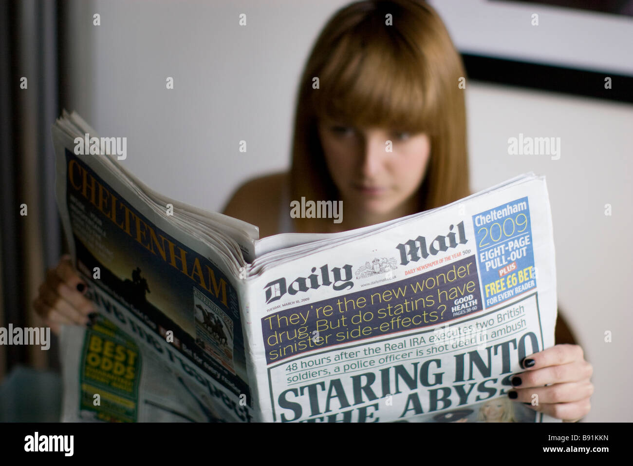 Jeune femme lisant un journal quotidien le Daily Mail Banque D'Images