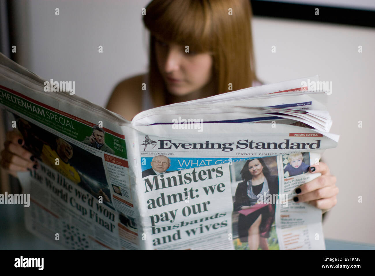Jeune femme lisant un journal quotidien l'Evening Standard Banque D'Images