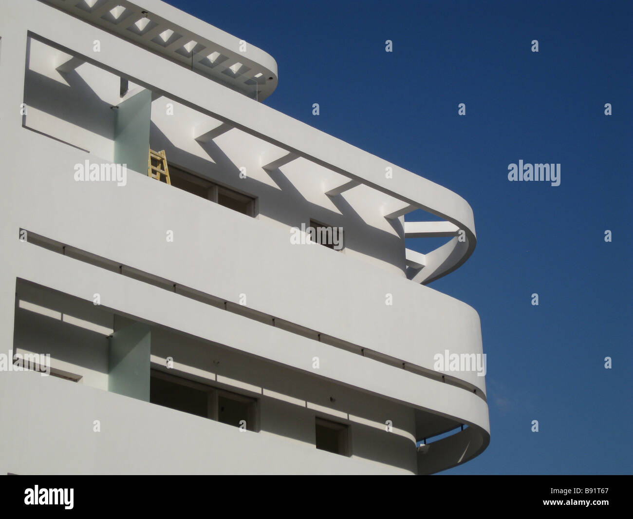 Rationaliser et balcon en saillie d'un béton incurvé de l'ombre d'un vieux bâtiment construit dans le style d'architecture Bauhaus dans les années 1930, à Tel Aviv, Israël Banque D'Images