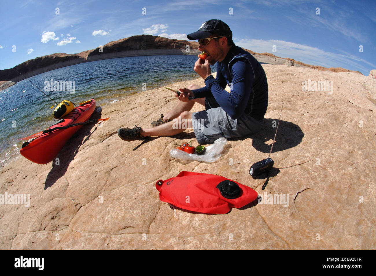 Un kayakiste de mer prend une pause déjeuner sur les rives du lac Powell, Utah Banque D'Images