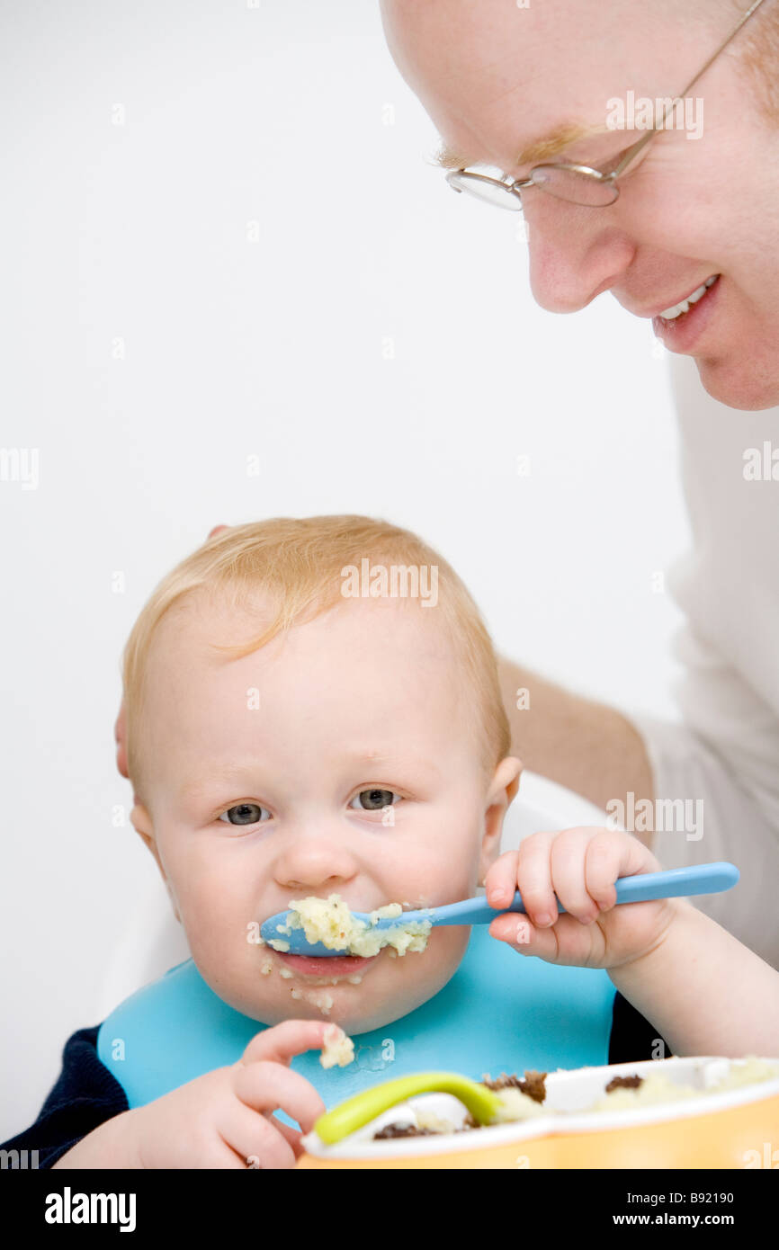 Un père regardant son fils manger en Suède. Banque D'Images