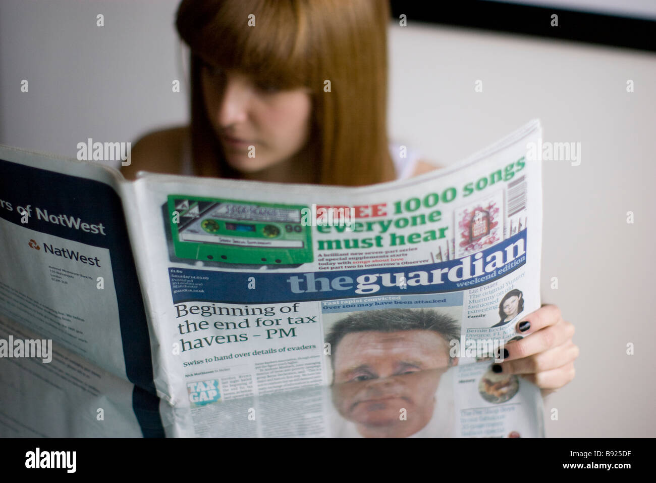 Jeune femme lisant UK quotidien britannique The Guardian Banque D'Images