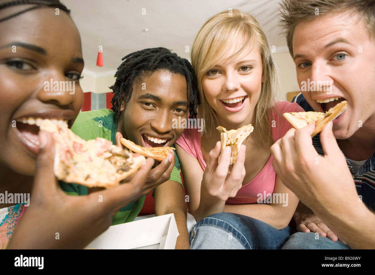 La culture des adolescents en Afrique du Sud Quatre jeunes adultes eating pizza Banque D'Images