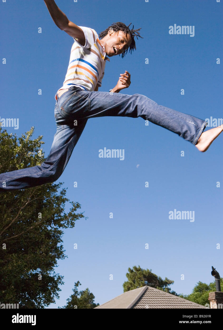 La culture de l'adolescence de l'Afrique du Sud Jeune homme sautant en l'air Banque D'Images