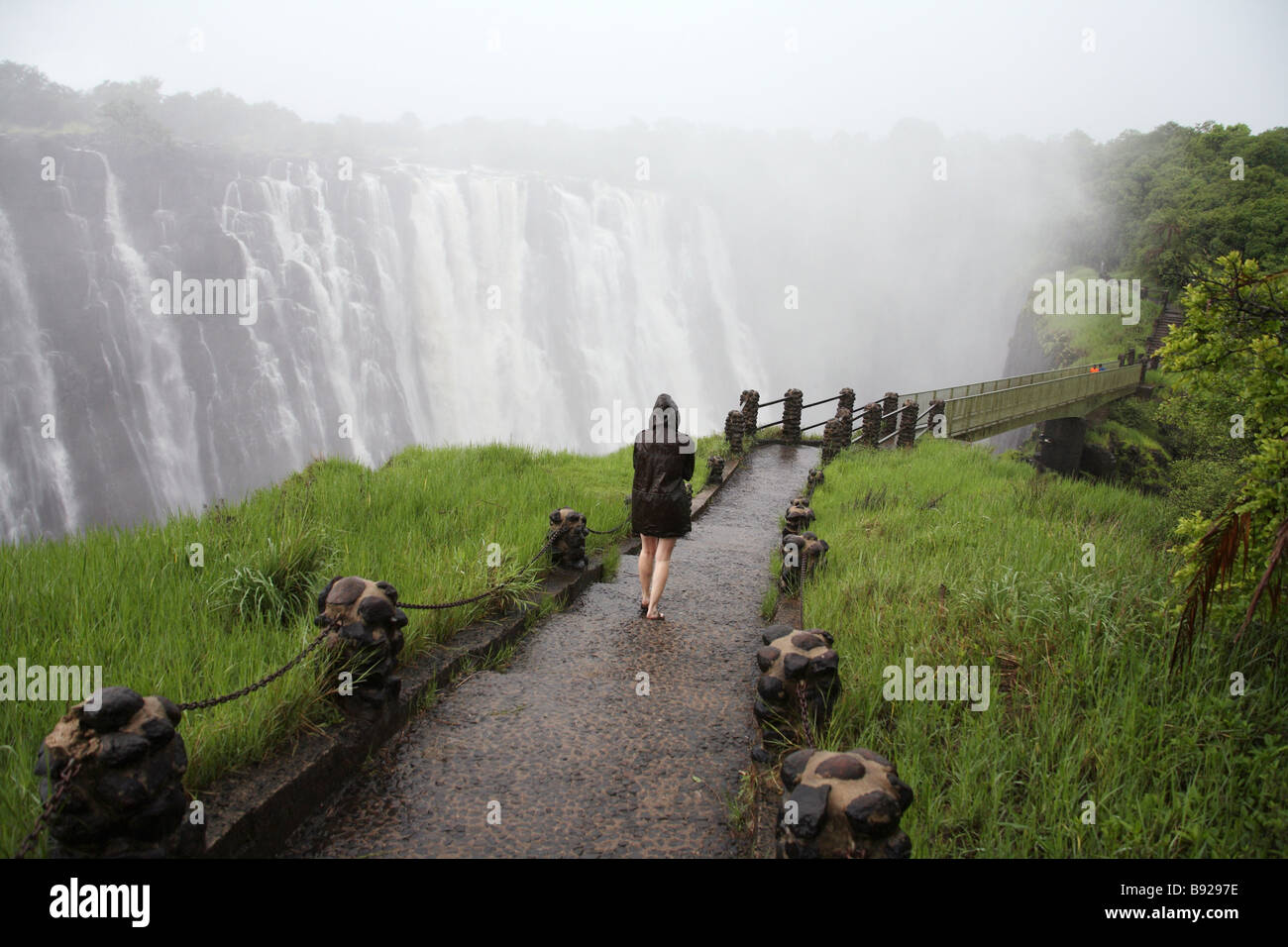 Femme marche vers le pied pont à Victoria Falls, Livingstone, Zambie Banque D'Images