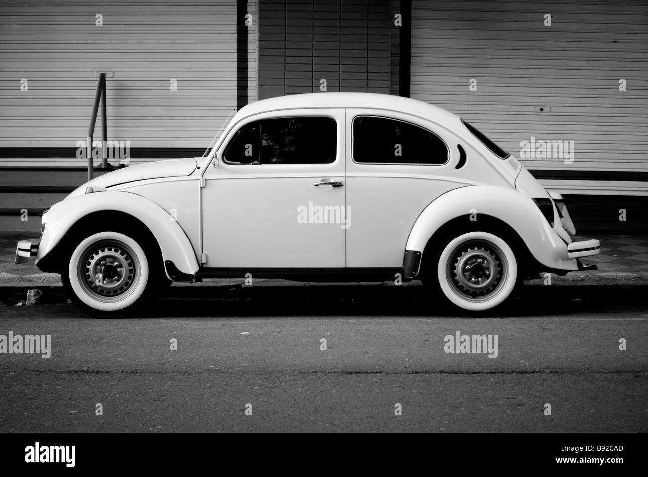 Vintage white volkwagen beetle avec pneus côté blanche garée dans la rue Banque D'Images