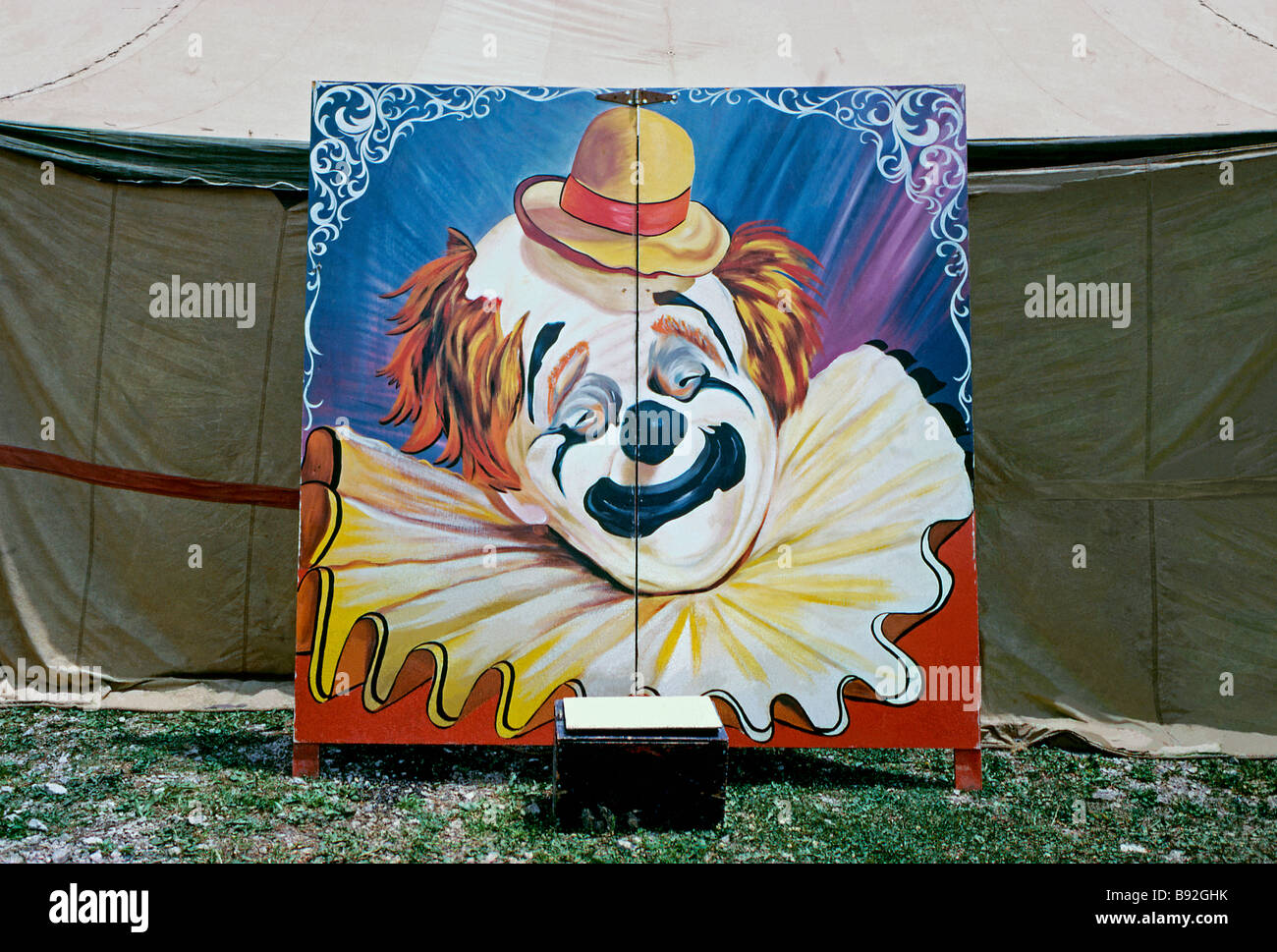 Peinture d'un visage de clown sur un panneau publicitaire en face de la grande haut, USA, c.1960 Banque D'Images